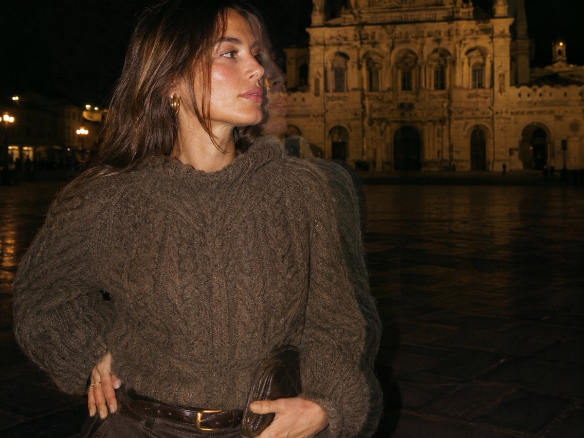 Chunky brown cable-knit jumper worn at night with gold hoops and a leather clutch