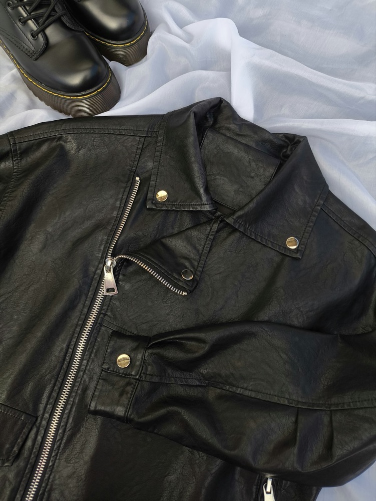 Vinted-style listing photo of a black leather biker jacket laid flat on a white sheet